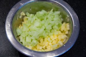 Versez les désde pommes dans le bol contenant les dés de concombre et mélangez avec le jus d'un demi citron vert