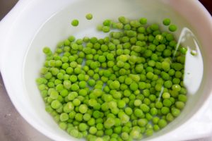 Égouttez les petits pois et versez-les dans de l'eau bien froide pour arrêter la cuisson et leur conserver une belle couleur verte