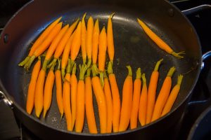 Faites revenir les carottes juste quelques minutes dans une poêle avec une grosse noix de beurre, le zeste de l'orange et une cuillerée à soupe de jus d'orange