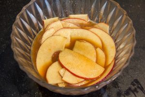 Trempez les tranches fines de pomme dans le sirop chaud