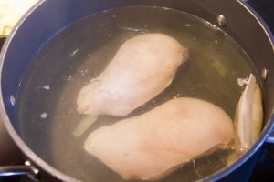 Faites pocher vos blancs de poulet dans une casserole d'eau parfumée avec un bouillon