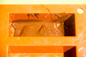 Versez une petite cuillère de chocolat fondu dans le fond des moules