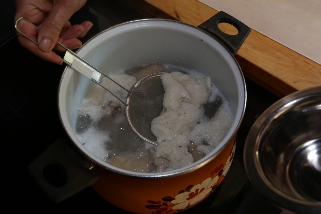 Ecumez à l'aide d'une passoire fine les impuretés qui se forment à la surface du bouillon