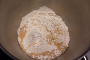 Versez une partie de la farine, le mélange eau miel levure dans un grand bol