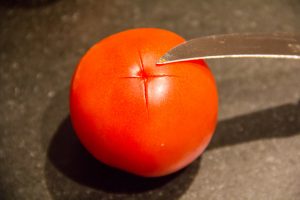 A l'aide d'un petit couteau tracez une petite croix sur la base de chaque tomate