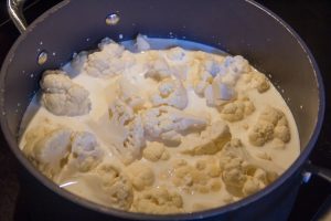 Versez les florettes de chou dans une grande casserole et recouvrez de lait à hauteur