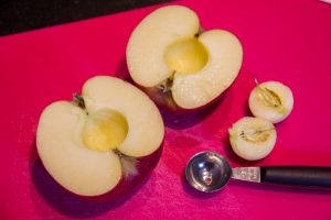Coupez les pommes en deux et évidez le centre à l'aide d'une cuillère parisienne