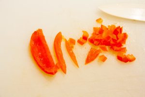 Coupez la tomate en 4. Épépinez la tomate et coupez-la en petits dés