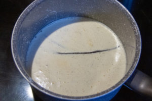 Portez le lait avec la gousse et les grains de vanille à ébullition